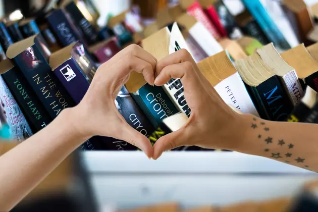 row of books, and two hands making a heart.