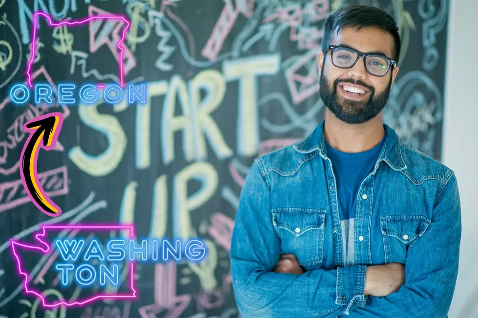 man standing in front of a chalk board with writing and designs written on it. Neon graphics of Washington and Oregon.